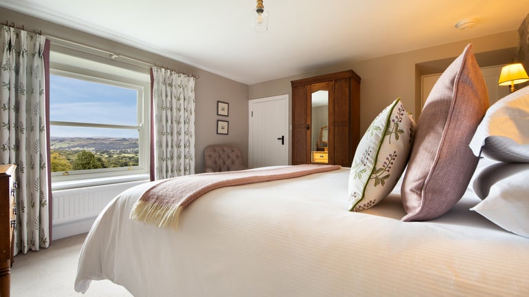 The super king-size bedroom at Druid's Cave Farmhouse, with views over the Nidderdale National Landscape, North Yorkshire